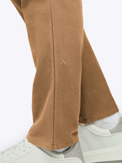 Brown pants worn with white sneakers on a white background